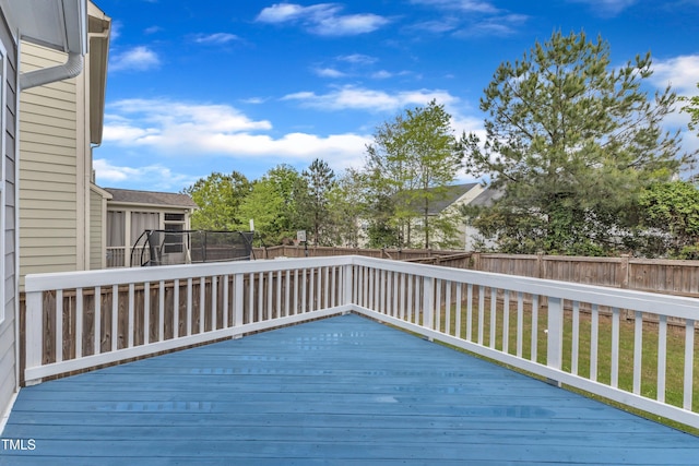 deck featuring a yard, a trampoline, and a fenced backyard
