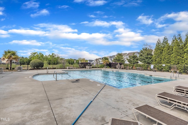 community pool with fence and a patio