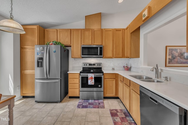 kitchen with stainless steel appliances, a sink, backsplash, light countertops, and hanging light fixtures