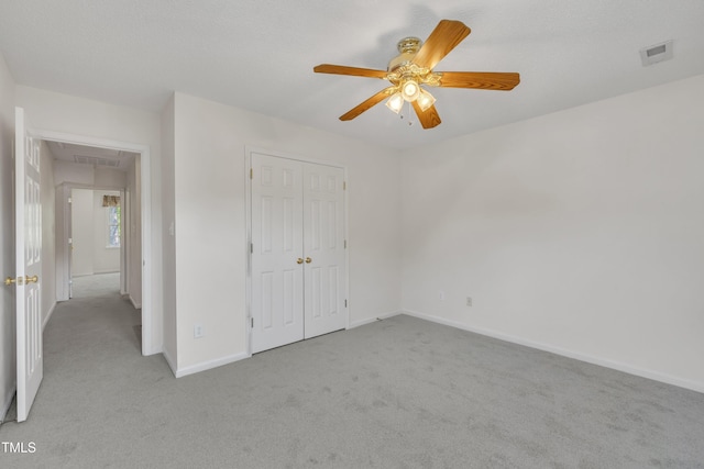 unfurnished bedroom featuring attic access, visible vents, carpet floors, and a closet
