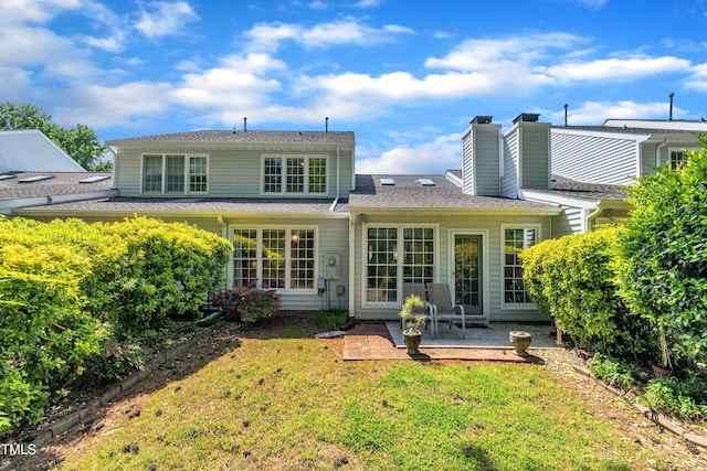 rear view of house with a yard and a patio