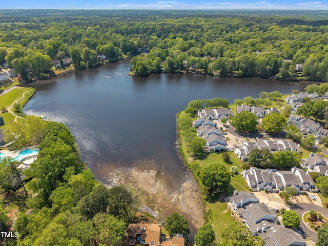 drone / aerial view featuring a residential view, a wooded view, and a water view