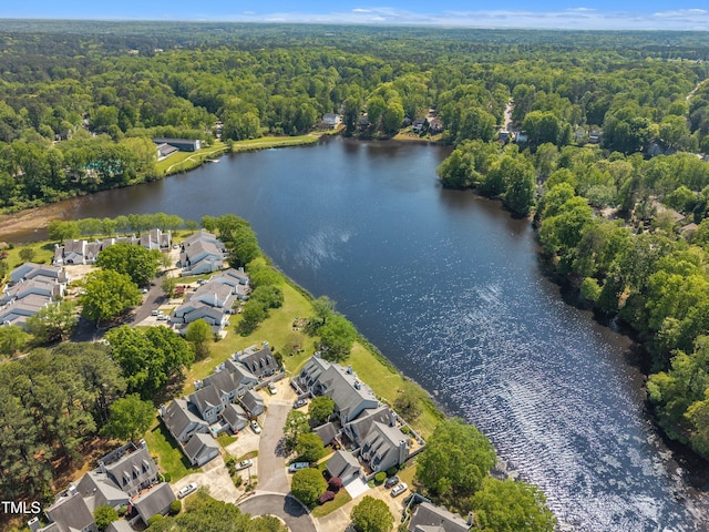 drone / aerial view featuring a view of trees, a residential view, and a water view
