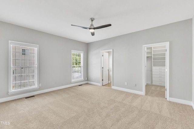 10603 Friendly Neighbor Ln, Raleigh, NC 27614 - unfurnished bedroom featuring baseboards, light carpet, a walk in closet, ceiling fan, and a closet