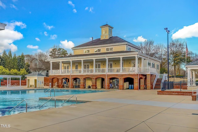 10603 Friendly Neighbor Ln, Raleigh, NC 27614 - back of property with a community pool, brick siding, a patio area, and stairway