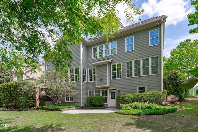 back of property with a patio area and a yard