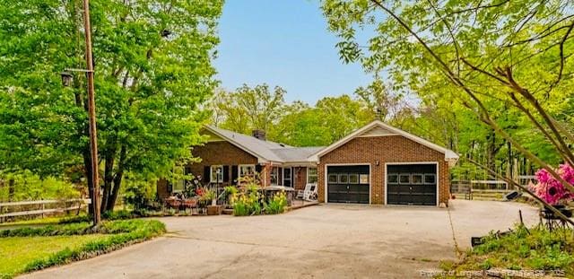 single story home with driveway, an attached garage, and fence