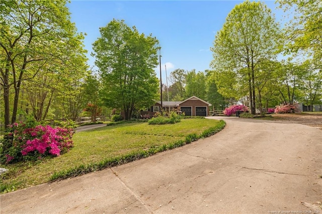 view of front of home featuring driveway, a garage, and a front yard