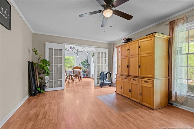 living area with light wood-type flooring, plenty of natural light, baseboards, and ornamental molding