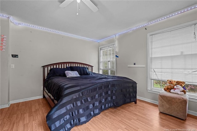 bedroom featuring wood finished floors, baseboards, and a ceiling fan