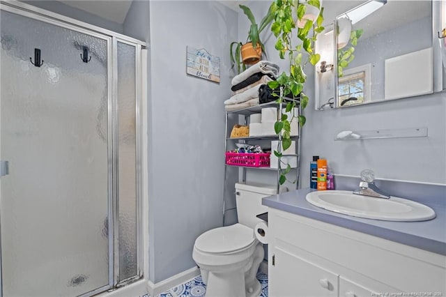 full bathroom with a shower stall, toilet, vanity, baseboards, and tile patterned flooring