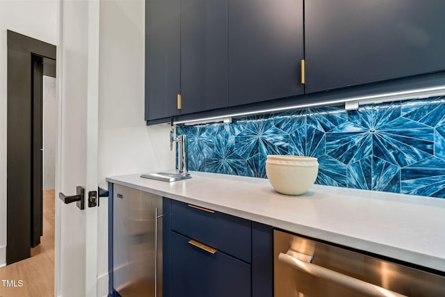 interior space featuring dishwasher, light countertops, blue cabinetry, backsplash, and modern cabinets