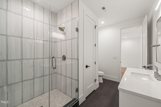 bathroom with a sink, a stall shower, toilet, and visible vents