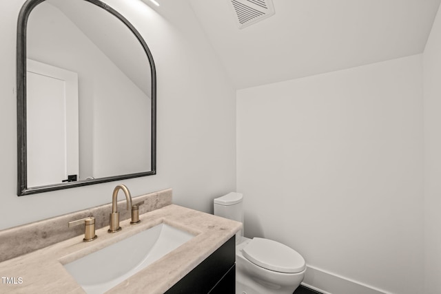 bathroom featuring toilet, visible vents, vaulted ceiling, and vanity