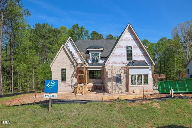 rear view of property with a yard and brick siding