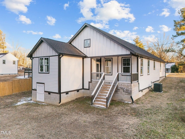 view of front of property with central AC, covered porch, fence, board and batten siding, and crawl space
