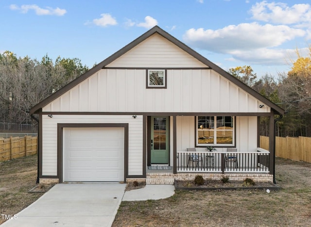 view of front facade featuring fence, covered porch, board and batten siding, concrete driveway, and an attached garage