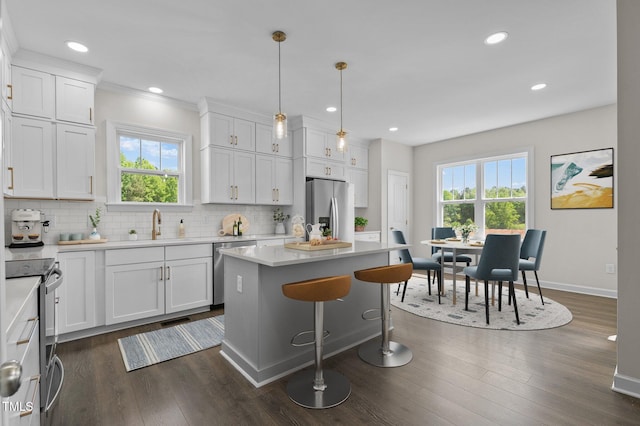 kitchen featuring a wealth of natural light, appliances with stainless steel finishes, a center island, and white cabinetry