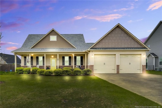 craftsman inspired home with brick siding, an attached garage, a lawn, and driveway
