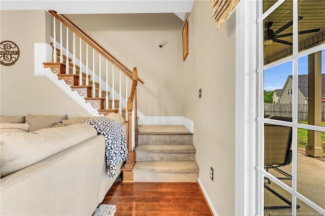staircase featuring baseboards and wood finished floors