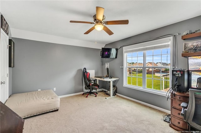 carpeted office with a ceiling fan and baseboards