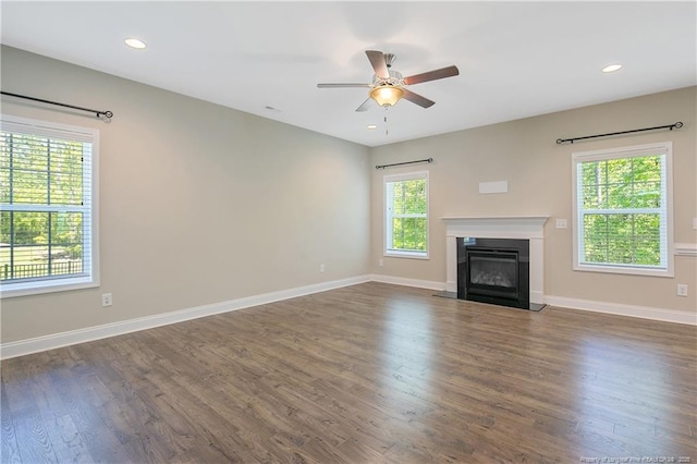 99 Wildlife Bridge Ct, Spring Lake, NC 28390 - unfurnished living room with baseboards, a glass covered fireplace, ceiling fan, and dark wood finished floors