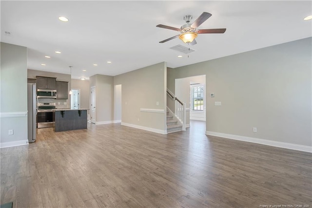 99 Wildlife Bridge Ct, Spring Lake, NC 28390 - unfurnished living room with baseboards, ceiling fan, stairs, and wood finished floors