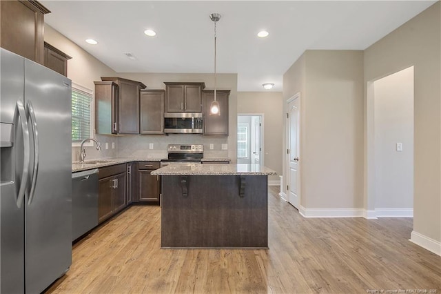 99 Wildlife Bridge Ct, Spring Lake, NC 28390 - kitchen featuring a sink, appliances with stainless steel finishes, dark brown cabinetry, and light stone countertops
