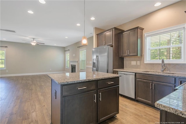 99 Wildlife Bridge Ct, Spring Lake, NC 28390 - kitchen featuring a sink, light stone counters, a ceiling fan, light wood finished floors, and appliances with stainless steel finishes