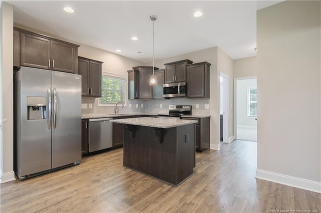 99 Wildlife Bridge Ct, Spring Lake, NC 28390 - kitchen featuring a kitchen island, dark brown cabinets, light wood finished floors, appliances with stainless steel finishes, and backsplash