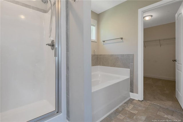 99 Wildlife Bridge Ct, Spring Lake, NC 28390 - bathroom with a garden tub, baseboards, a walk in closet, and a shower stall