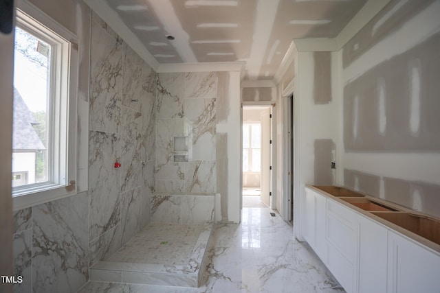 full bathroom featuring ornamental molding, marble finish floor, and a marble finish shower