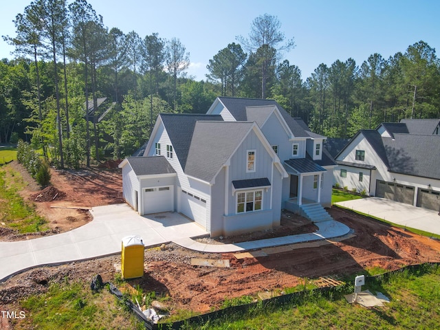 7301 Wexford Woods Ln, Wake Forest, NC 27587 - view of front of property with concrete driveway, an attached garage, board and batten siding, and a standing seam roof