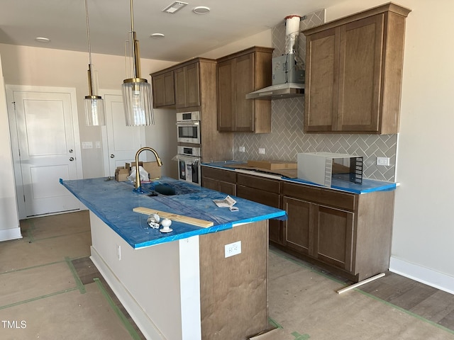 3022 White Rail Dr, Fuquay Varina, NC 27526 - kitchen with wall chimney range hood, a kitchen island with sink, tasteful backsplash, decorative light fixtures, and stainless steel double oven