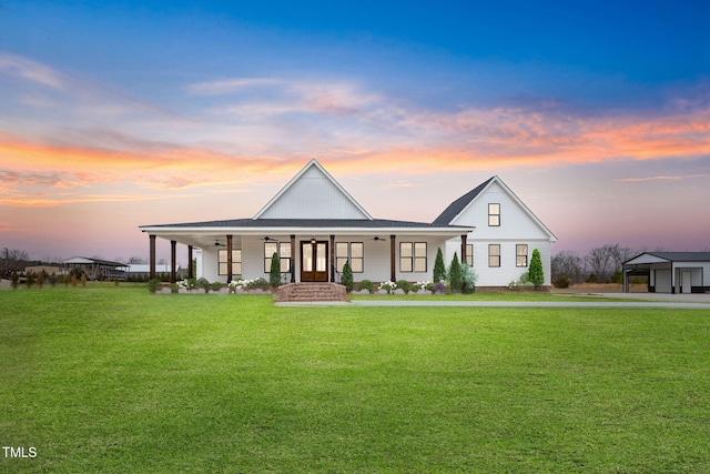 modern farmhouse with a ceiling fan, covered porch, and a front yard