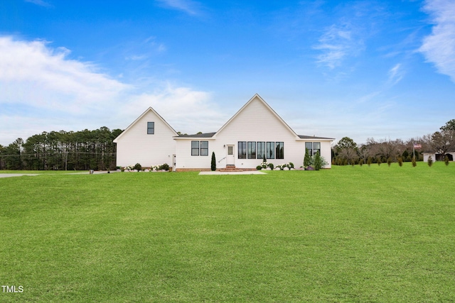 rear view of property featuring a lawn