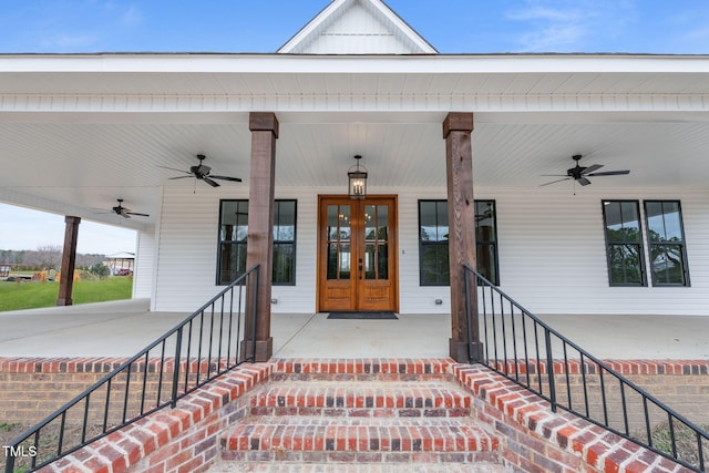view of exterior entry with covered porch, ceiling fan, and french doors