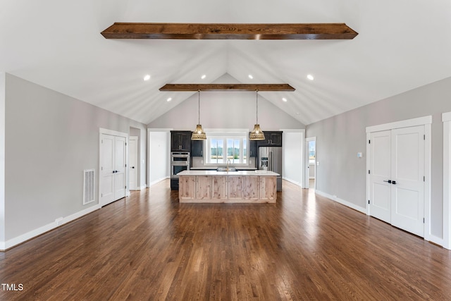 kitchen with stainless steel appliances, a kitchen island with sink, beam ceiling, visible vents, and light countertops