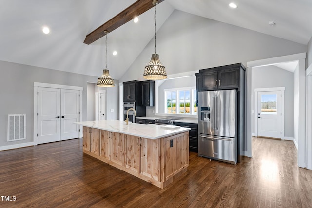 kitchen featuring visible vents, light stone countertops, a center island with sink, appliances with stainless steel finishes, and high vaulted ceiling