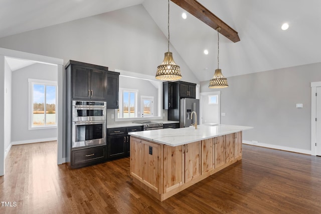 kitchen featuring a kitchen island with sink, a healthy amount of sunlight, dark wood-style flooring, high vaulted ceiling, and appliances with stainless steel finishes