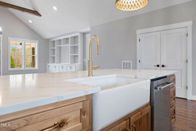 kitchen with a sink, vaulted ceiling, recessed lighting, light stone counters, and dishwasher