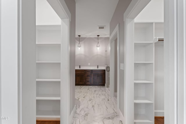 bathroom with visible vents, marble finish floor, and a walk in closet