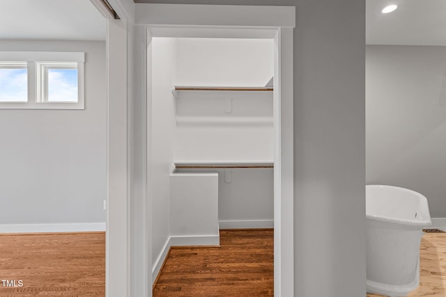 bathroom featuring baseboards, recessed lighting, and wood finished floors