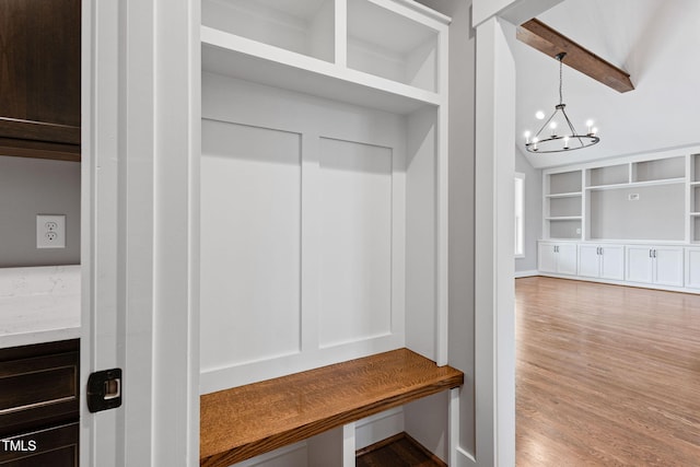 mudroom with lofted ceiling with beams, a notable chandelier, built in features, and wood finished floors