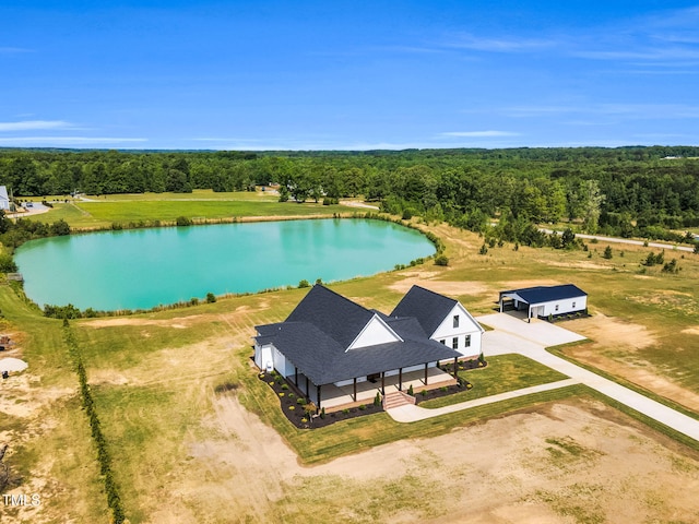 birds eye view of property featuring a water view and a wooded view
