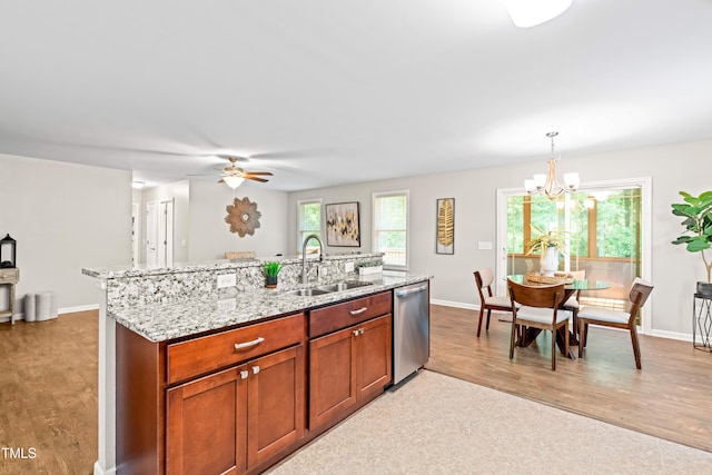 kitchen featuring stainless steel dishwasher, baseboards, a sink, and ceiling fan with notable chandelier