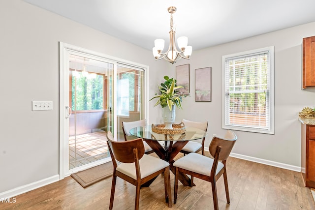 dining area featuring baseboards, a chandelier, and light wood-type flooring