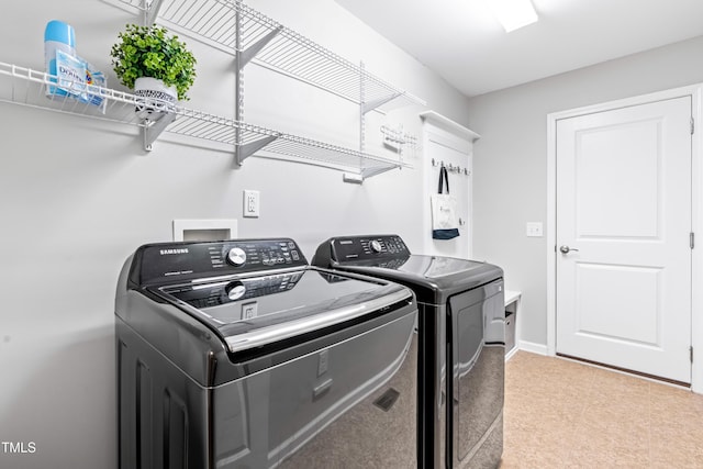 laundry room with laundry area, baseboards, and washing machine and clothes dryer