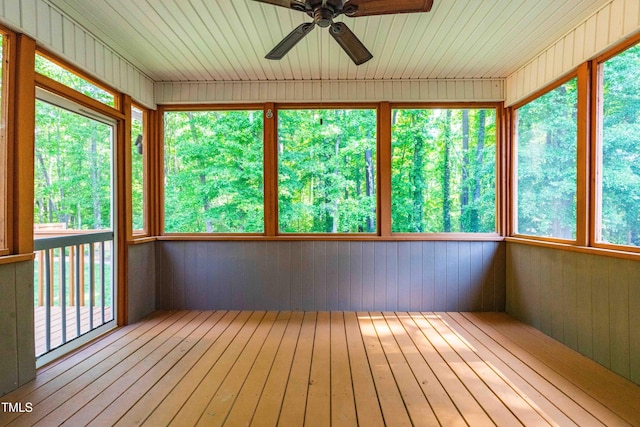 unfurnished sunroom with ceiling fan, hardwood / wood-style flooring, and a wealth of natural light