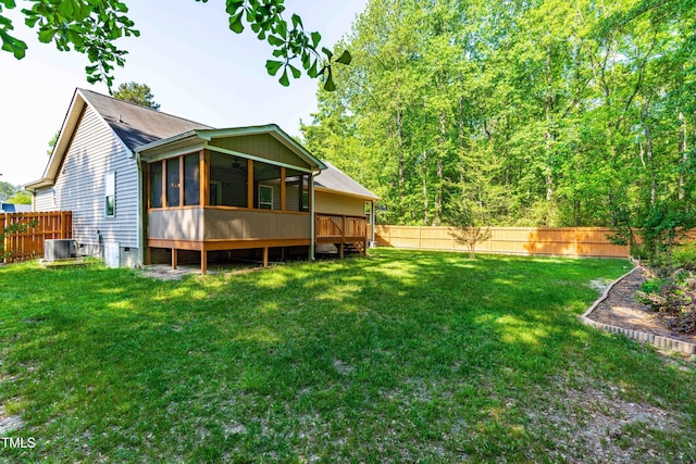back of property featuring a yard, a fenced backyard, a sunroom, and central air condition unit